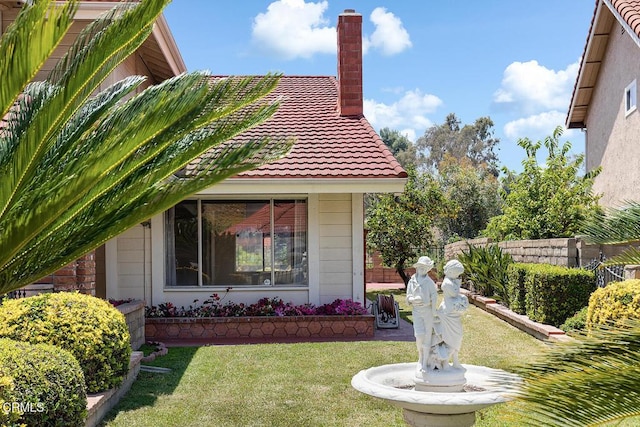 2026 Thomas Pl, West Covina, CA 91792 - view of side of property featuring a tiled roof, a lawn, and a chimney