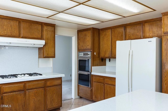 2026 Thomas Pl, West Covina, CA 91792 - kitchen with white appliances, under cabinet range hood, and brown cabinetry