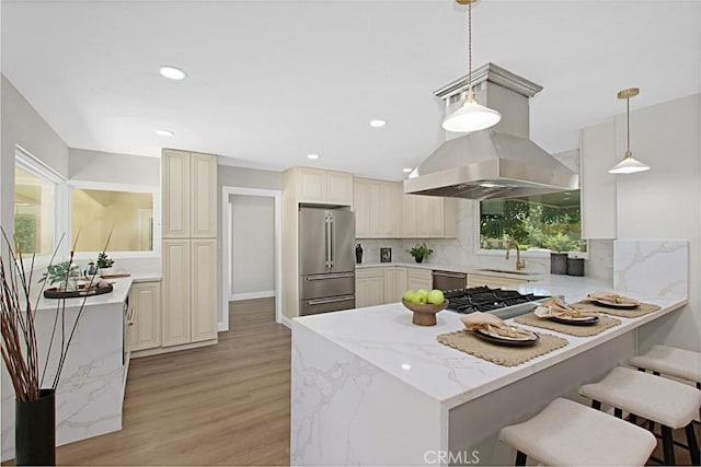 1604 N Laurel Ave, Upland, CA 91784 - kitchen featuring appliances with stainless steel finishes, island range hood, a peninsula, light wood finished floors, and backsplash