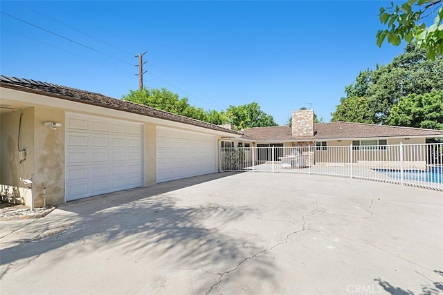 1604 N Laurel Ave, Upland, CA 91784 - view of front of house featuring a chimney, a garage, stucco siding, and driveway