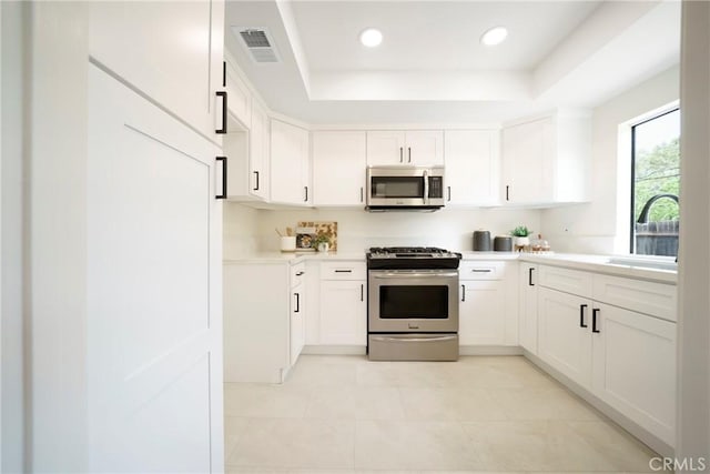 1927 Huntington Dr Unit C, Duarte, CA 91010 - kitchen with appliances with stainless steel finishes, a tray ceiling, light countertops, light tile patterned flooring, and white cabinets
