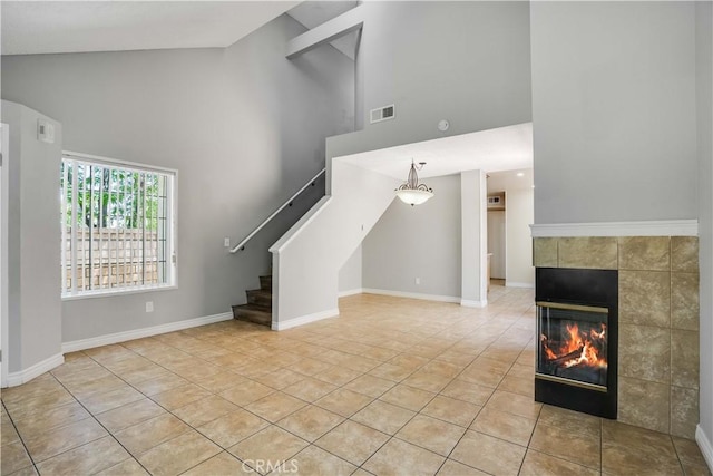 37940 42nd St E Unit 129, Palmdale, CA 93552 - unfurnished living room with high vaulted ceiling, light tile patterned floors, stairway, and a fireplace
