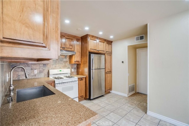 37940 42nd St E Unit 129, Palmdale, CA 93552 - kitchen with freestanding refrigerator, white range with gas cooktop, under cabinet range hood, backsplash, and recessed lighting