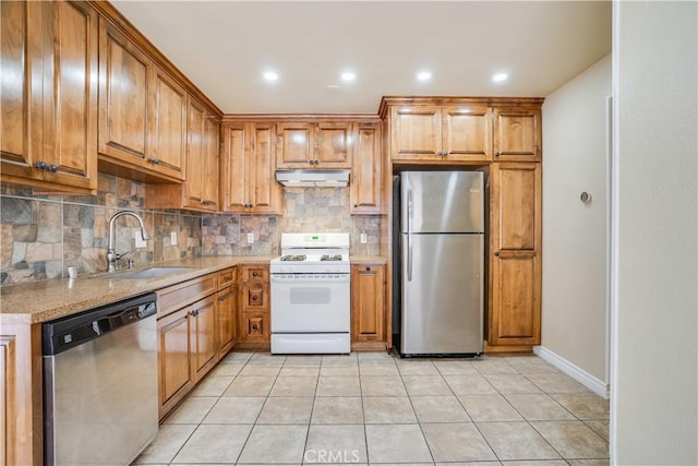 37940 42nd St E Unit 129, Palmdale, CA 93552 - kitchen featuring appliances with stainless steel finishes, under cabinet range hood, tasteful backsplash, brown cabinetry, and recessed lighting