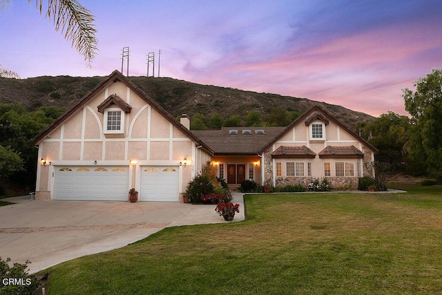 2981 Yucca Dr, Camarillo, CA 93012 - tudor-style house with stucco siding, concrete driveway, a lawn, and a chimney