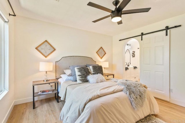 1948 Caminito De La Cruz, Chula Vista, CA 91913 - bedroom with a barn door, light wood-style flooring, ensuite bathroom, and a ceiling fan
