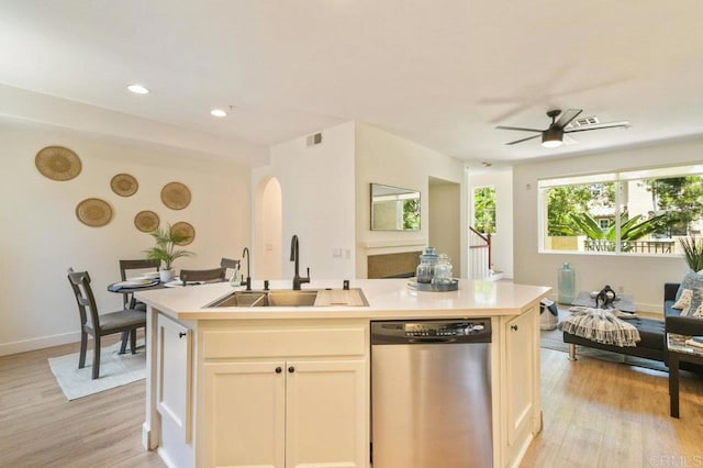 1948 Caminito De La Cruz, Chula Vista, CA 91913 - kitchen featuring dishwasher, arched walkways, light wood-type flooring, an island with sink, and light countertops