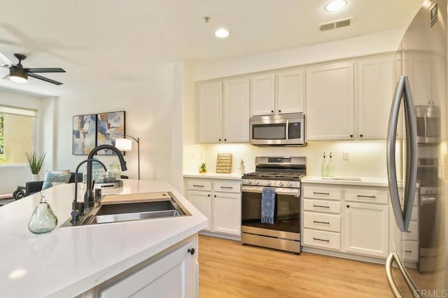 1948 Caminito De La Cruz, Chula Vista, CA 91913 - kitchen featuring appliances with stainless steel finishes, light countertops, a ceiling fan, white cabinetry, and light wood-type flooring