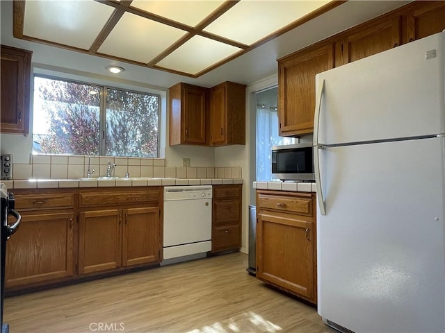 1039 Maple St, Arroyo Grande, CA 93420 - kitchen featuring white appliances, tile countertops, light wood-style floors, and brown cabinetry