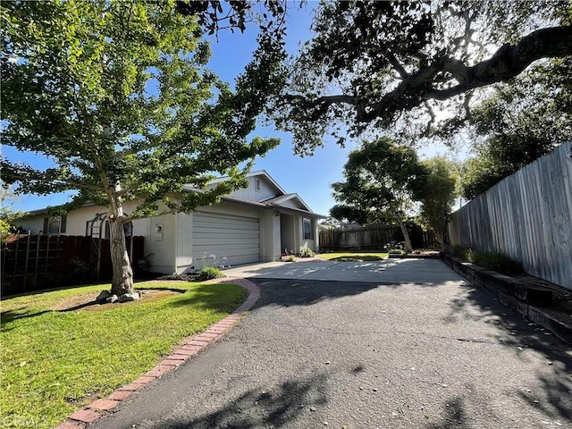 1039 Maple St, Arroyo Grande, CA 93420 - view of side of property with a fenced backyard, asphalt driveway, and a garage