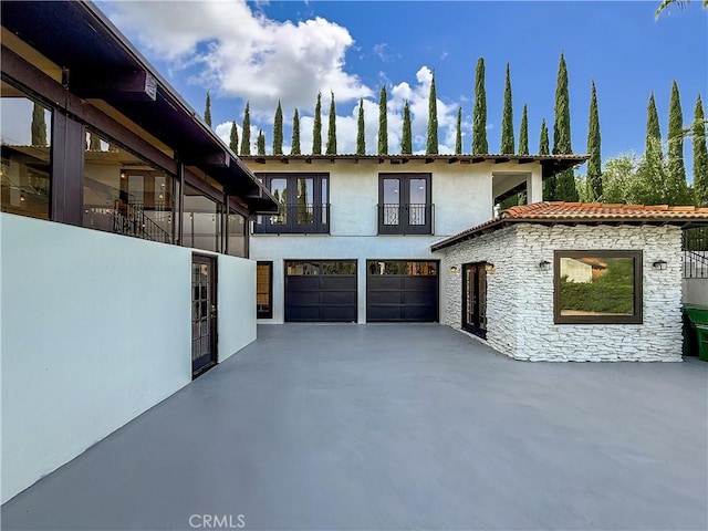 567 Lone Oak Dr, Thousand Oaks, CA 91362 - view of front of house with french doors, stone siding, concrete driveway, an attached garage, and stucco siding