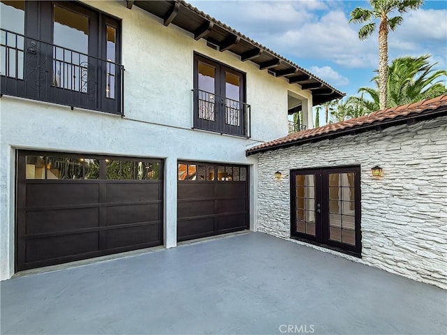 567 Lone Oak Dr, Thousand Oaks, CA 91362 - view of side of property with french doors, stone siding, a garage, and stucco siding