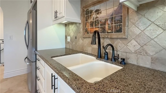 567 Lone Oak Dr, Thousand Oaks, CA 91362 - kitchen featuring dark stone counters, tasteful backsplash, white cabinetry, freestanding refrigerator, and arched walkways