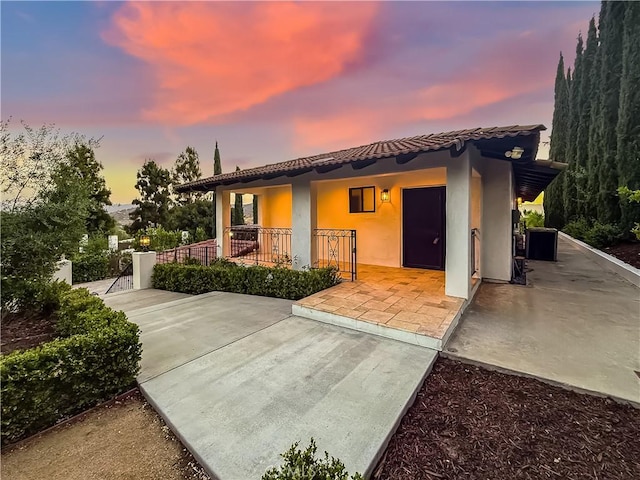 567 Lone Oak Dr, Thousand Oaks, CA 91362 - back of house at dusk featuring a tile roof, stucco siding, and a patio area