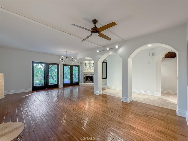 567 Lone Oak Dr, Thousand Oaks, CA 91362 - unfurnished living room with wood finished floors, a ceiling fan, a chandelier, a large fireplace, and arched walkways