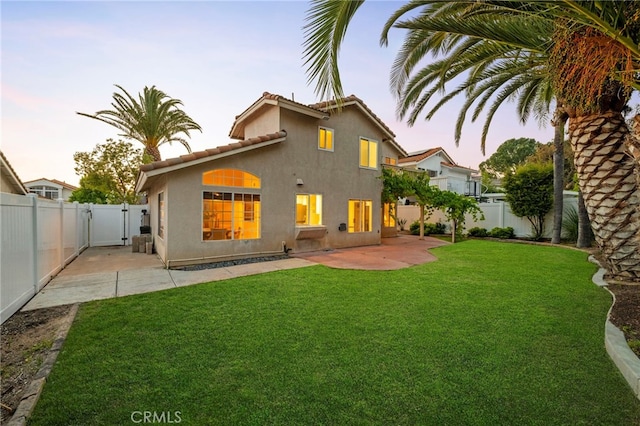 41024 Montelena Cir, Temecula, CA 92591 - back of house at dusk featuring a gate, a fenced backyard, a patio area, and stucco siding