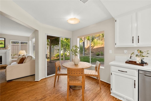 41024 Montelena Cir, Temecula, CA 92591 - dining room with light wood-style flooring and a glass covered fireplace
