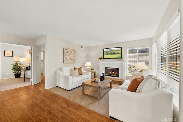 41024 Montelena Cir, Temecula, CA 92591 - living room with a glass covered fireplace, wood finished floors, and healthy amount of natural light