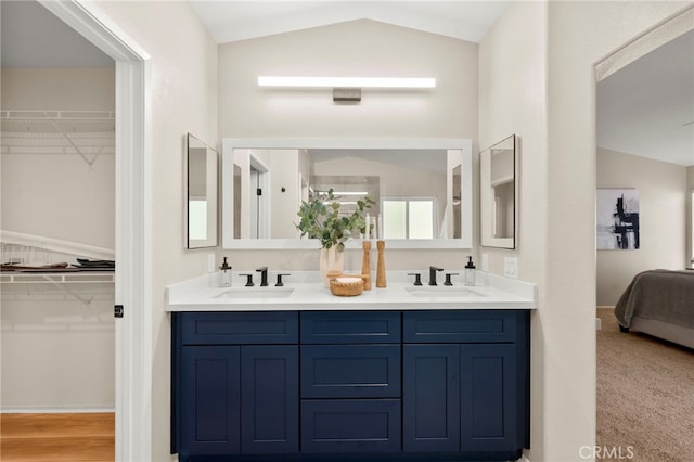 41024 Montelena Cir, Temecula, CA 92591 - bathroom featuring lofted ceiling, double vanity, connected bathroom, and a walk in closet