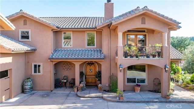 9942 Sunfish Cir, Paso Robles, CA 93446 - back of property featuring a tile roof, stucco siding, a chimney, a balcony, and a patio area