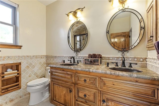 9942 Sunfish Cir, Paso Robles, CA 93446 - bathroom featuring tile patterned floors, double vanity, tile walls, and a wainscoted wall