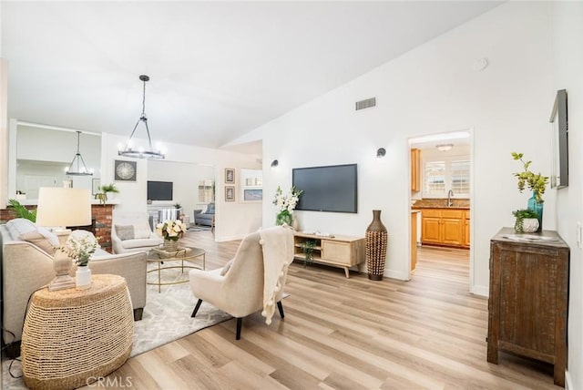 6772 Rook Dr, Huntington Beach, CA 92647 - living area with light wood-type flooring, a chandelier, and high vaulted ceiling