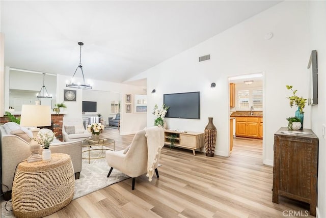 6772 Rook Dr, Huntington Beach, CA 92647 - living room with light wood-type flooring, a chandelier, and high vaulted ceiling