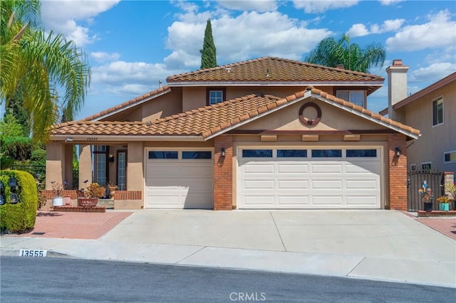 13555 Via, San Remo, Chino Hills, CA 91709 - mediterranean / spanish house featuring concrete driveway, a garage, and brick siding