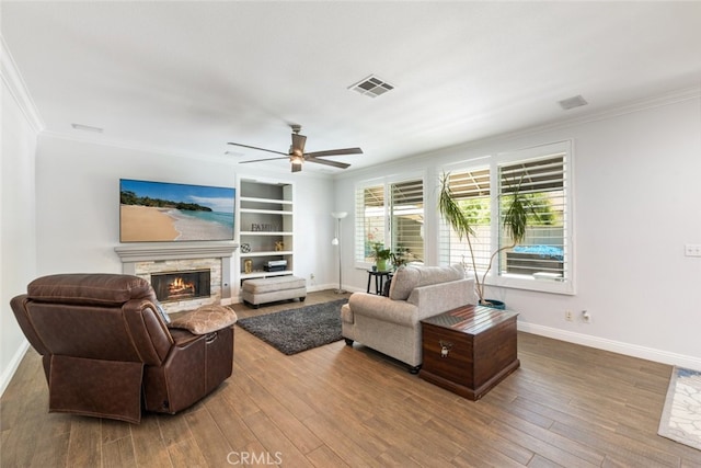 3720 Gunnison Cir, Corona, CA 92881 - living area featuring ornamental molding, a warm lit fireplace, wood finished floors, a ceiling fan, and built in features