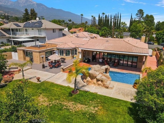 2335 N San Antonio Ave, Upland, CA 91784 - rear view of property with a patio, a mountain view, an outdoor pool, and a lawn