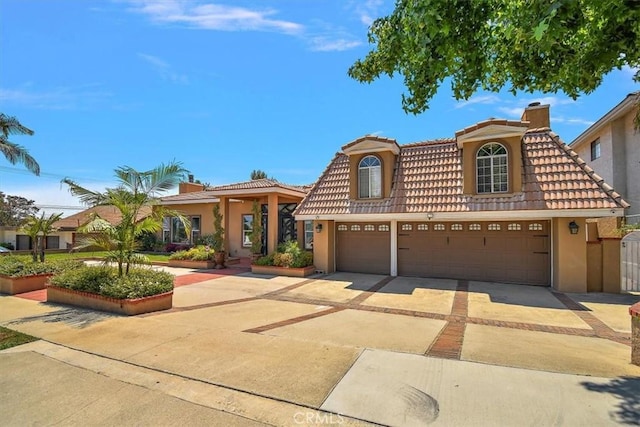 2335 N San Antonio Ave, Upland, CA 91784 - mediterranean / spanish home with stucco siding, a tile roof, driveway, and a chimney