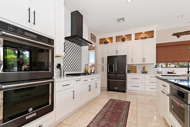 2335 N San Antonio Ave, Upland, CA 91784 - kitchen featuring black refrigerator with ice dispenser, double oven, wall chimney exhaust hood, tasteful backsplash, and recessed lighting