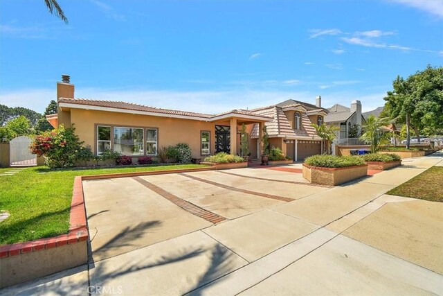 2335 N San Antonio Ave, Upland, CA 91784 - view of front of property featuring a front yard, concrete driveway, a tiled roof, a chimney, and stucco siding