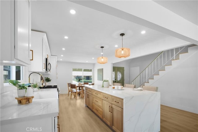 801 Navajo Dr, Riverside, CA 92507 - kitchen featuring recessed lighting, light wood finished floors, a kitchen island, pendant lighting, and light stone countertops