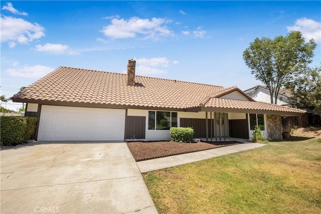 801 Navajo Dr, Riverside, CA 92507 - view of front of house featuring a tile roof, driveway, an attached garage, a chimney, and a front yard