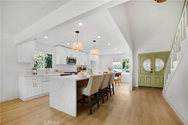 801 Navajo Dr, Riverside, CA 92507 - kitchen featuring stainless steel microwave, healthy amount of natural light, light wood-style floors, and recessed lighting
