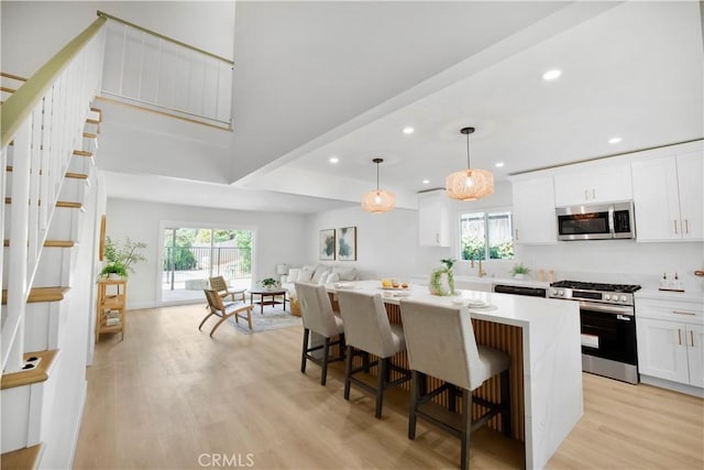 801 Navajo Dr, Riverside, CA 92507 - kitchen featuring appliances with stainless steel finishes, a kitchen island, light wood-style floors, plenty of natural light, and recessed lighting
