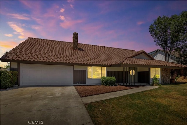 801 Navajo Dr, Riverside, CA 92507 - view of front facade featuring a tile roof, driveway, a garage, a lawn, and a chimney