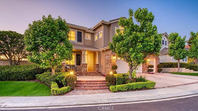 5 Kennedy Ct, Coto De Caza, CA 92679 - obstructed view of property featuring concrete driveway, an attached garage, brick siding, and a porch