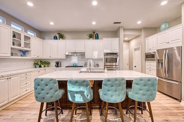 5 Kennedy Ct, Coto De Caza, CA 92679 - kitchen with stainless steel appliances, under cabinet range hood, white cabinetry, a breakfast bar, and recessed lighting