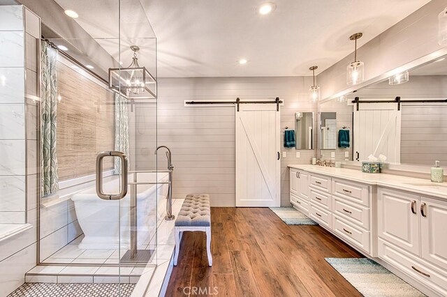 5 Kennedy Ct, Coto De Caza, CA 92679 - bathroom with double vanity, wood finished floors, a shower stall, recessed lighting, and a tub to relax in