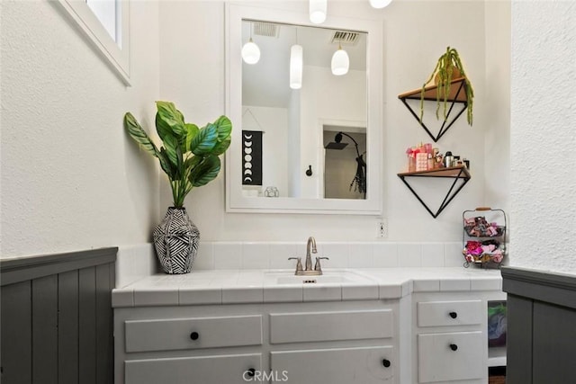 8 Barton Pkwy, Oakdale, CA 95361 - bathroom featuring vanity, a textured wall, and wainscoting