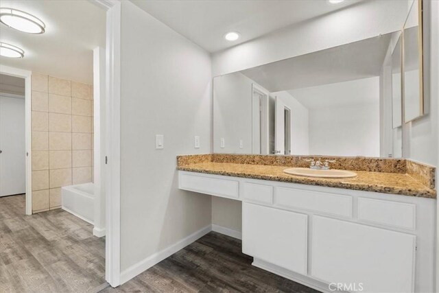 1077 Santo Antonio Dr Unit 54, Colton, CA 92324 - bathroom featuring wood finished floors, vanity, and recessed lighting