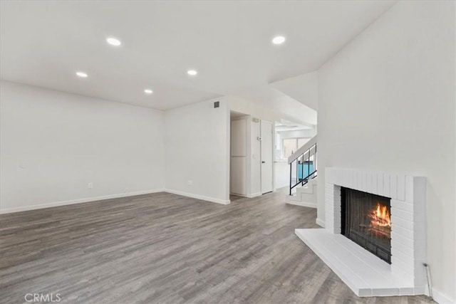 1077 Santo Antonio Dr Unit 54, Colton, CA 92324 - unfurnished living room featuring wood finished floors, recessed lighting, a fireplace, and stairway