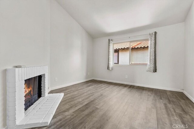 1077 Santo Antonio Dr Unit 54, Colton, CA 92324 - unfurnished living room with wood finished floors, lofted ceiling, and a fireplace