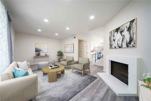 1077 Santo Antonio Dr Unit 54, Colton, CA 92324 - living area featuring wood finished floors, recessed lighting, stairway, and a brick fireplace
