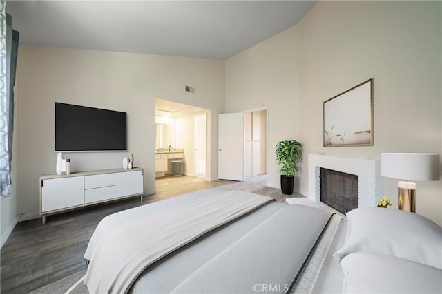 1077 Santo Antonio Dr Unit 54, Colton, CA 92324 - bedroom featuring wood finished floors, high vaulted ceiling, a fireplace, and connected bathroom
