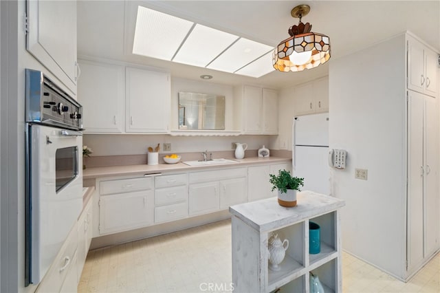 1670 Interlachen Rd Unit 43J, Seal Beach, CA 90740 - kitchen featuring light countertops, white cabinets, white appliances, light flooring, and pendant lighting