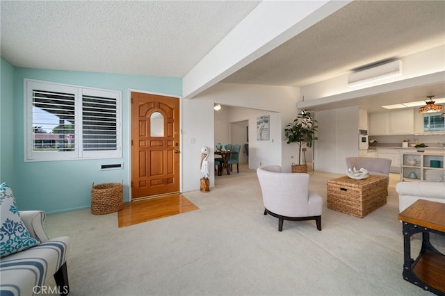 1670 Interlachen Rd Unit 43J, Seal Beach, CA 90740 - living area featuring light colored carpet, a textured ceiling, and a wall unit AC