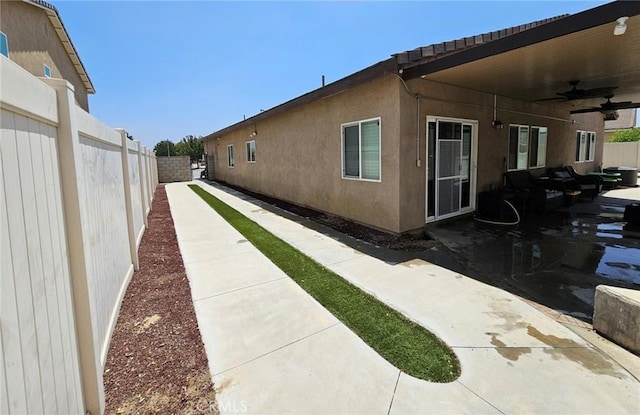 4979 Graphite Creek Rd, Jurupa Valley, CA 91752 - view of side of property featuring a ceiling fan, a fenced backyard, a patio area, and stucco siding